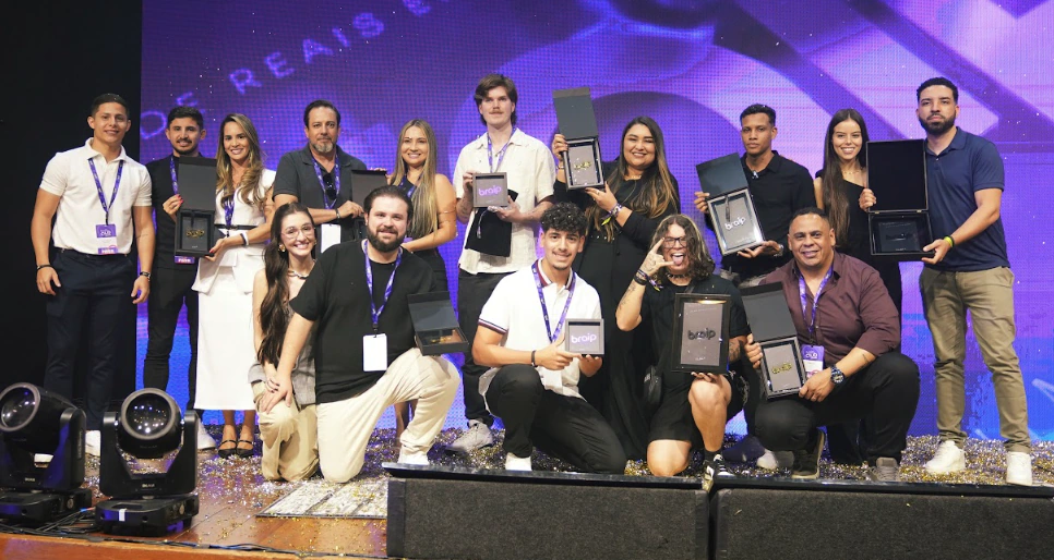 Participantes reunidos no palco com suas premiações do Braip Club